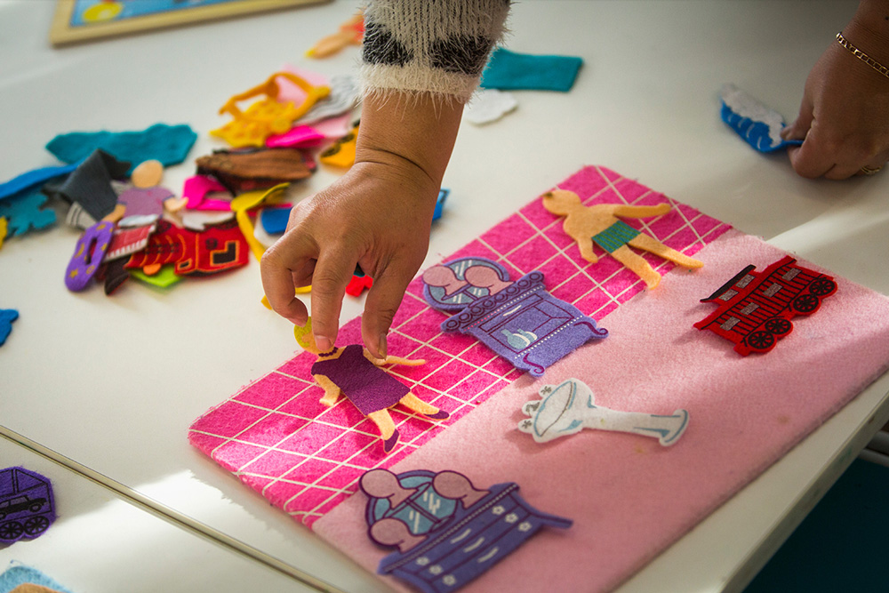 This is a photo of hands playing with a magnetic kids board