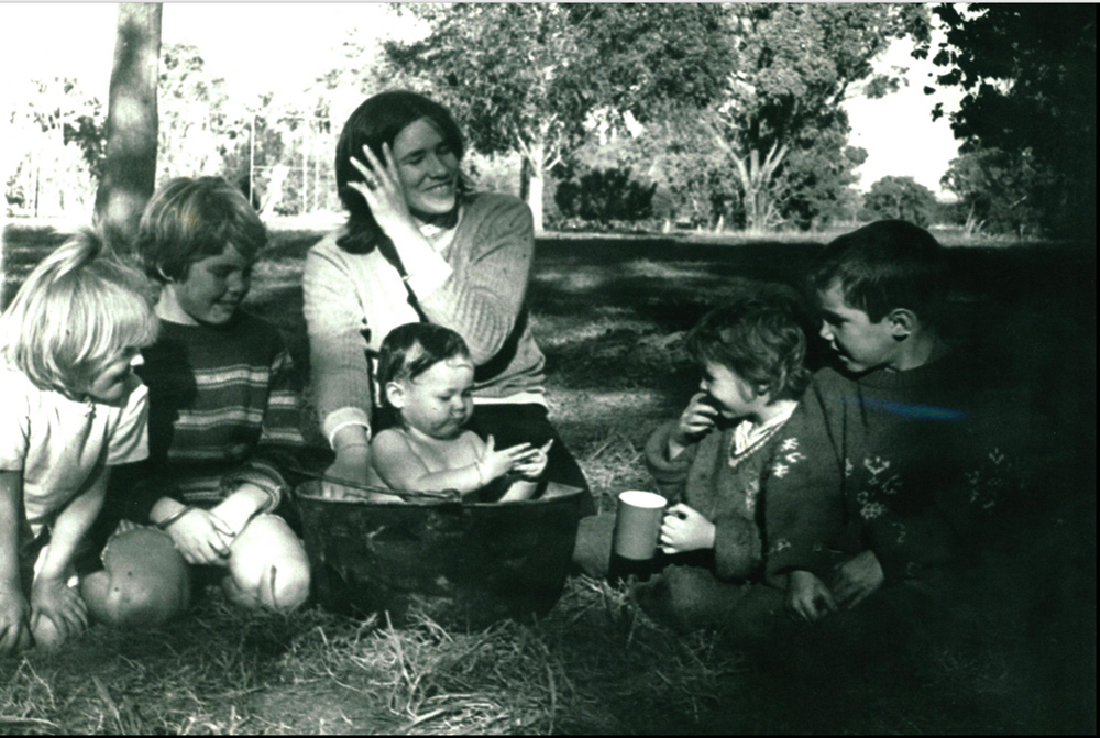 This is a photo of children enjoying a play group in the park, organised at the Family Centre. They are happy and smiling.