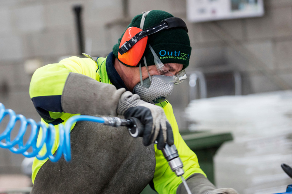This is a photo of Given the Chance employer, Outlook Environmental,  whohas helped us find work for people seeking asylum. A man is wearing safety gear and working