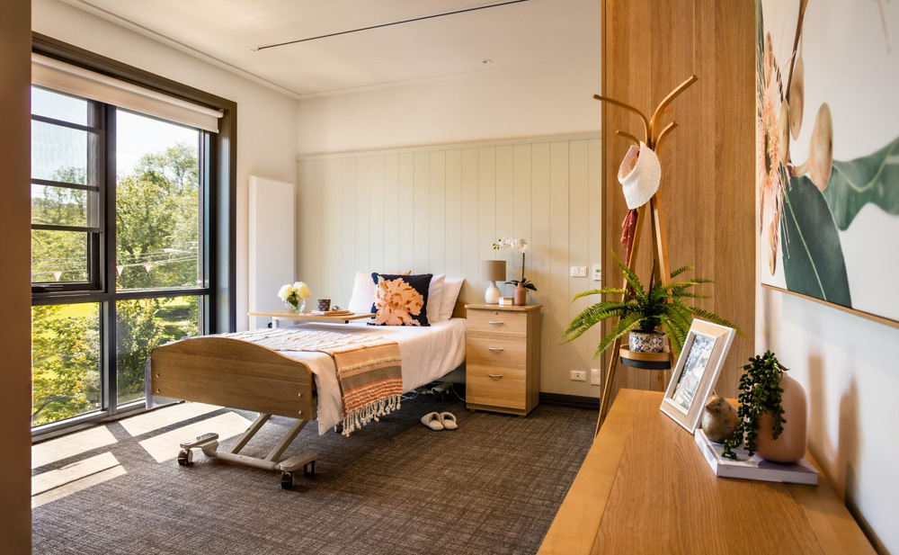 This is a photo of a resident's room at BSL's aged care residence in Clifton Hill. The decor is yellow and white, and the room is bright and inviting.